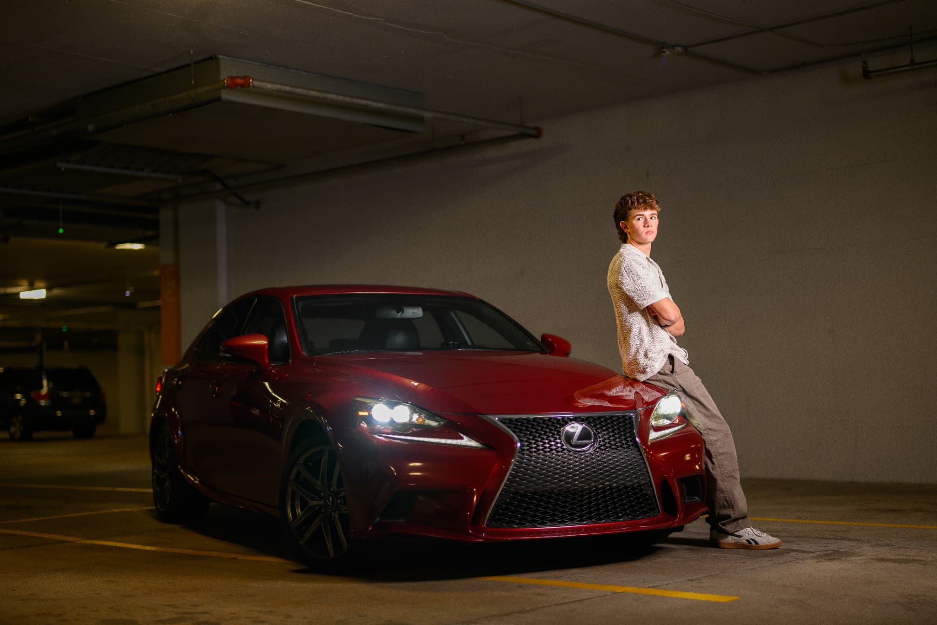 Clayton, founder of Driven Details, next to a freshly detailed red Lexus